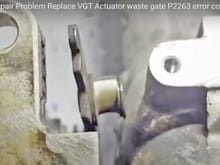Youtube video screen capture of a worn variable vane actuator linkage pin. This is the pin the eye-bolt pivots on and this is the eye-bolt known for wear and the P2263 code. Eye bolt available, this linkage arm pin is not. 