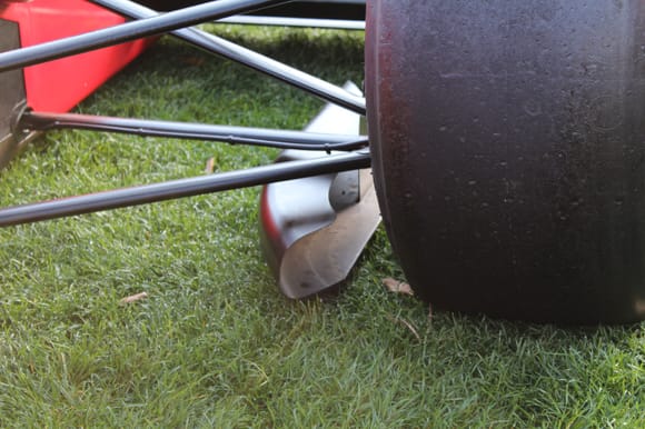 Front wing vortex channelizer to keep dirty air from going under the lower body undertray