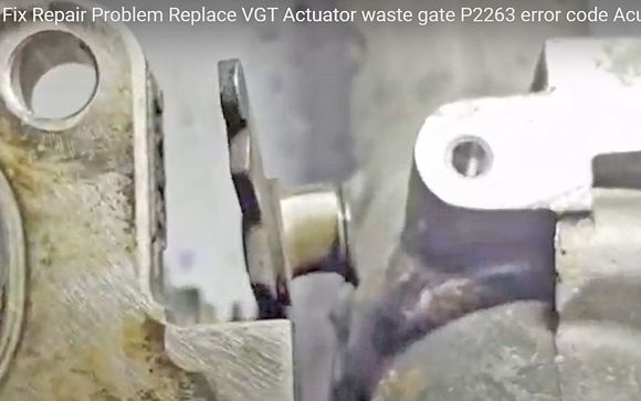 Youtube video screen capture of a worn variable vane actuator linkage pin. This is the pin the eye-bolt pivots on and this is the eye-bolt known for wear and the P2263 code. Eye bolt available, this linkage arm pin is not. 