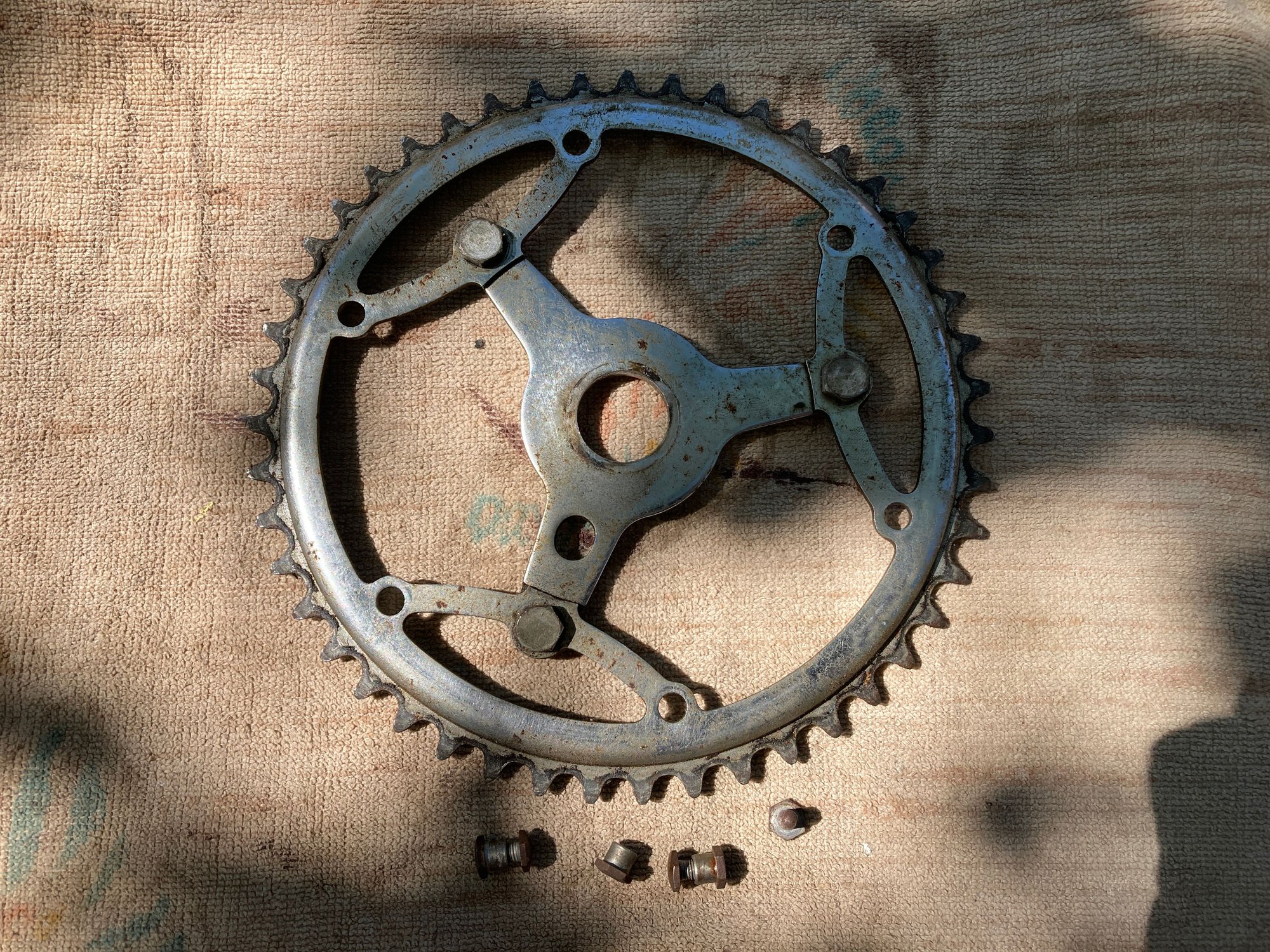 These three nuts and bolts on the chain wheel do not come off. They move freely, but do not separate.