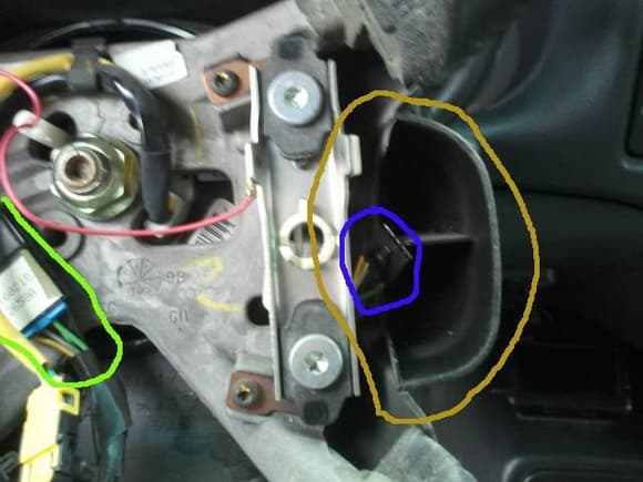 The connector indicated by the green line is the main connector for the remote radio controls. The connector surrounded blue is for the right hand side controls. There is a similar one on the left. The plastic piece indicated by the brown line is the part of the far-side steering wheel cover that encloses the side of the switches.