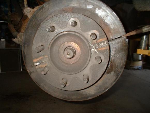 Cut across rotor with a air cutoff grinder to split rotor to get it off the hub. Then split the rotor with a cold chisel and hammer. It fell off then.