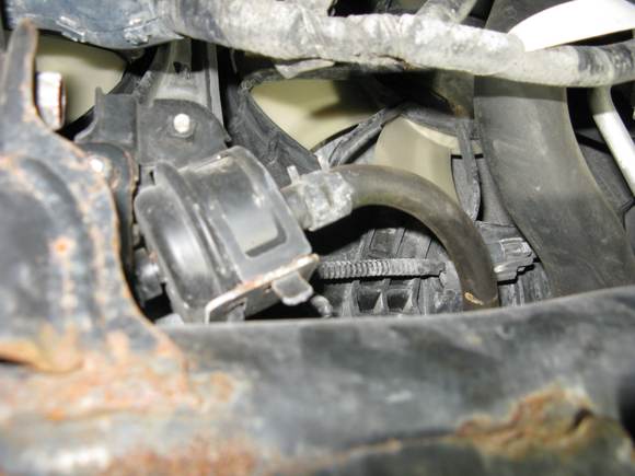 From underneath and towards front-tube on right goes to radiator/trans cooler, tube one left leads to  banjo plug on left (pass.) side transmission case.