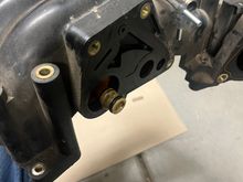 Where the piece was connected. It had springs inside the white plastic piece that stuck out, they fell while I was taking the upper intake manifold off & I do not think I found all of them (I found 2, one large & one small)