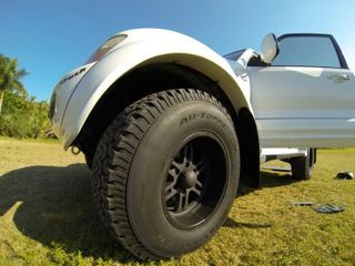 In order to fit these tires and maintain low center of gravity, they cut away the body before attaching custom fiberglass fenderflares.  Even the windshield washer fluid tank is custom as the new tires take up more space in the engine bay.