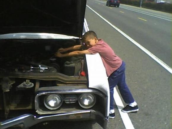 My youngest son loosenin' a valve cover on my Delta 88.