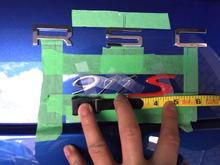 the 911S is 4+3/4" inches wide, and doesnt sit under the R or the C above (but the R and the C can be used as a not-to-intersect guideline).  note the 911S is all TOP ALIGNED via the painters tape (as per oem standards).  notice that during the test fit i marked on the painters tape where the badging will go once i remove the adhesive.  finally don't forget that the height of the 911 is 7/8" inches (this will ensure you achieve a perfect oem slant).