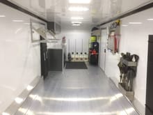Side door closed, LED lighting on, overhead vent closed with sunlight coming in- rear of trailer to front