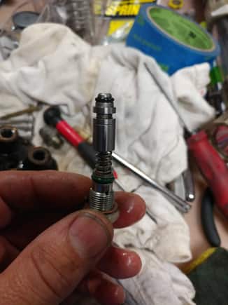 If this didn't come out when you removed the threaded in piece or the spring then insert a thin magnetic pick up tool into the hole and see if this is free enough to slide out with the tool