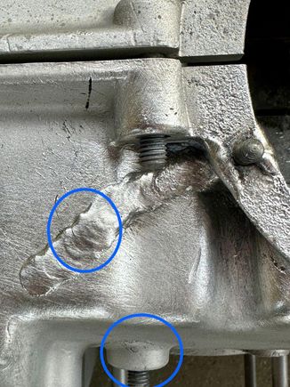 The upper circle shows what might be a crack in the weld. The lower circle shows scabbing. This might be minor or covering something major. I would take a pick and poke at the area. More than likely material will flake off. It is what is underneath you need to inspect. This could be nothing or a stress riser that could cause that boss to eventually fail. All depends on the stress level it sees. 