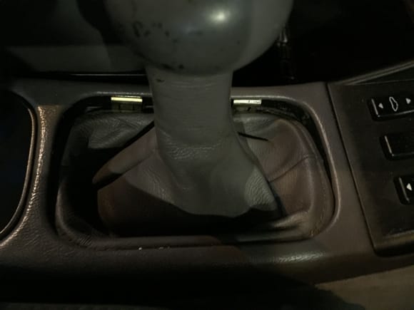 Use  your bare hands to push down on the driver side about 1" from the corners and the boot will push right down past the tension clips.