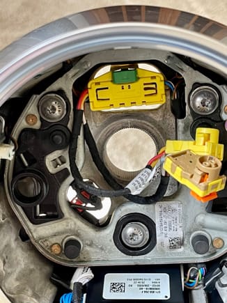 Upper yellow connector connects the steering wheel to the clock spring. Yellow and tan colored circular connectors go to the airbag. Connector located at the 8 O'Clock position is for the heating function