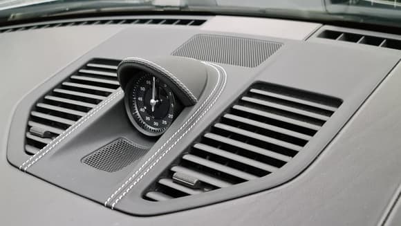 Another photo of the center vents/speaker grille and Sport Chrono hood wrapped in leather with deviated stitching. 