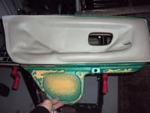 This is an inner panel from a rear door. You can see that it had separated and it has a rip in the vinyl. I guess at this point you could peel off the vinyl and bring it to an upholstery shop and have them recover it. Then re-install it yourself, save a bit of money.