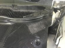Turn the clips and prise the cover off the engine bulkhead .There May be a couple of screws to remove at the ends near the glass as well.