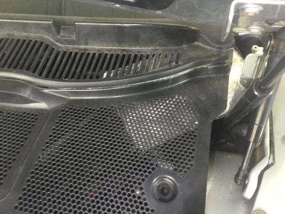 Turn the clips and prise the cover off the engine bulkhead .There May be a couple of screws to remove at the ends near the glass as well.