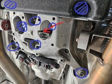 Bolts/nuts in question circled in blue.  Red arrow points out the transmission mount behind the crossmember.