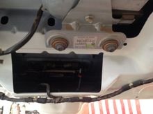 The little red piece is where the strap attaches.  Pulling up at that point releases the latch