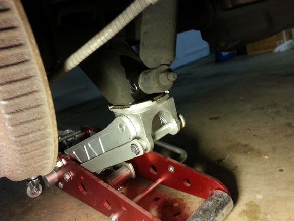 Use the jack to compress the shock and support the axle as you take the leaves off