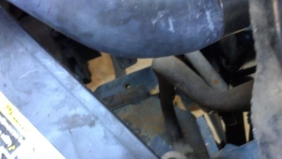Trying to get at the bent up stuff below, mounting the radiator was a bitch due to my left side being tagged and yanked back out by the original owner