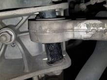 This is the driver side lower arm #2 bushing that failed.  The arm should be positioned at the bottom of the bracket in the picture (towards rear of car), but the failed bushing has allowed the arm to shift to the opposite end of the bracket (towards front of car).