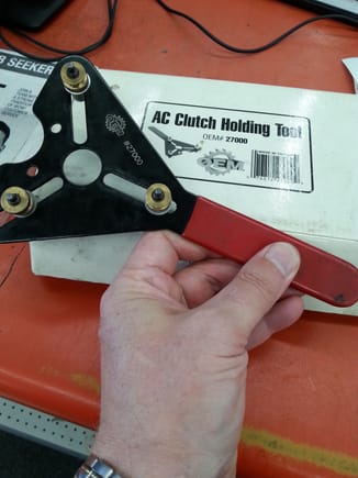 AC Compressor clutch cover holding tool available as rental fromn.....AutoZone.
DO NOT BUY THEIR AFTERMARKET CLUTCH!!