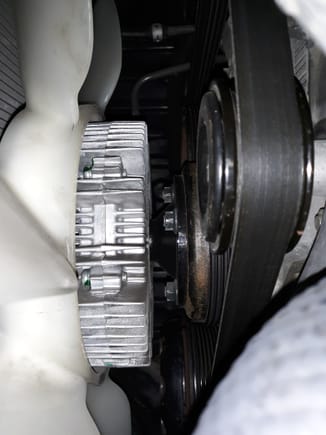 A spacer between the fan clutch and fan bracket hub would move the fan more fully inside the shroud and provide comfortable clearance between fan blades and LS430 hose.
Not just a flat spacer however.