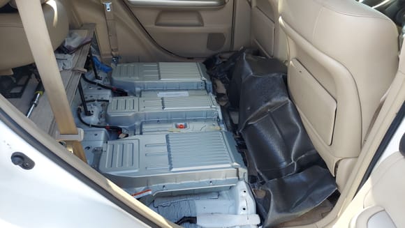 I tucked the carpet up against the front seats.  There is no need to remove it further.  The metal battery cover is light but  it will slice you up.  It has plenty of sharp edges.