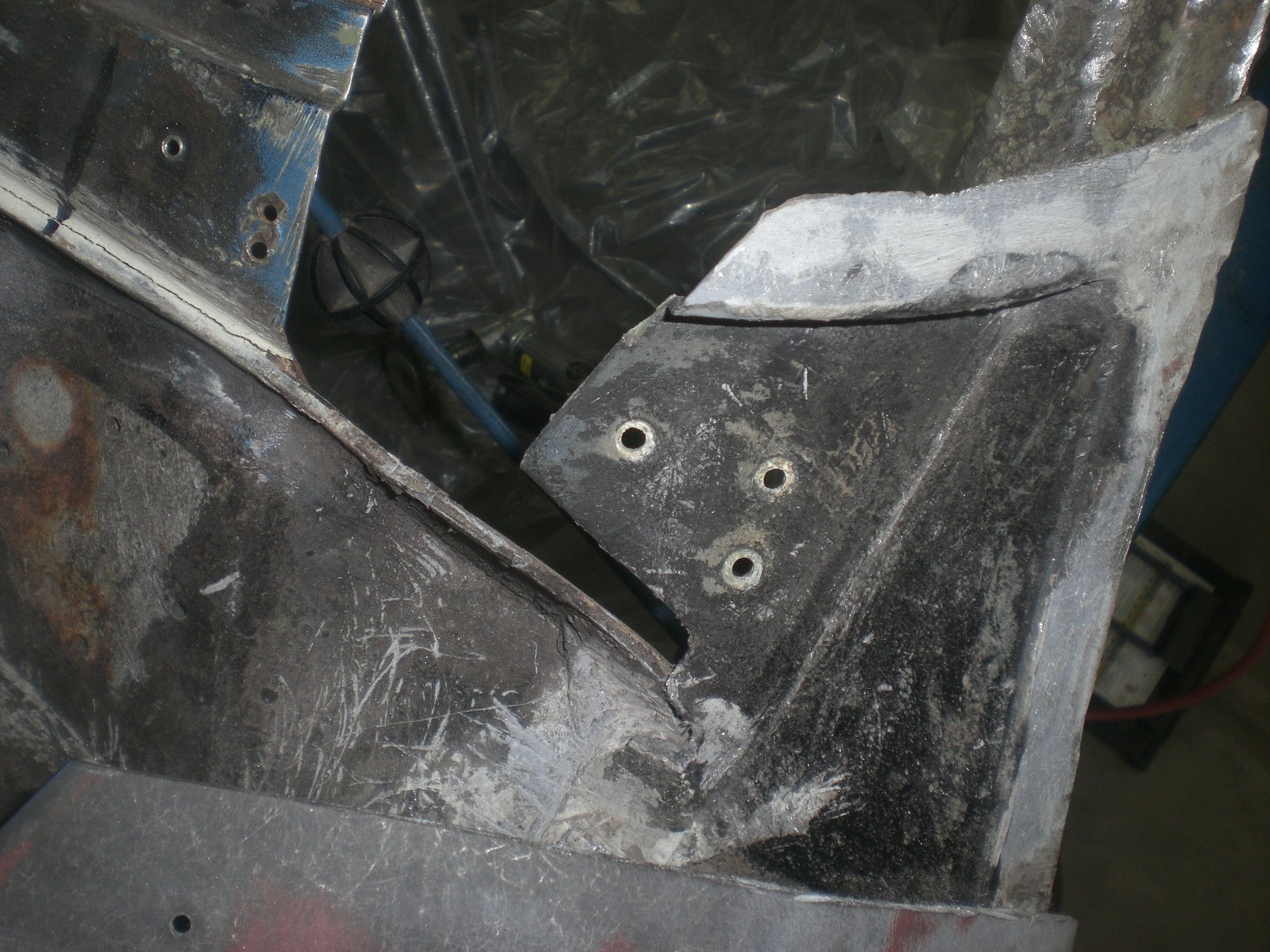 Top view of the bonding panel piece.  Fender cut is visible along bottom of photo.  Just below and slightly left of the 3 rivet holes the top edge of the wiper trough rear vertical wall is also visible.