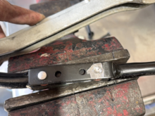 Where the 2 "bushings" were rivieted in the shifter rod/arm circled in the diagram.  Here the rivet head is being ground out to release the loosely installed "bushing".