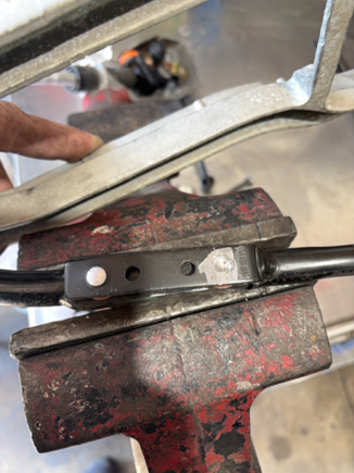 Where the 2 "bushings" were rivieted in the shifter rod/arm circled in the diagram.  Here the rivet head is being ground out to release the loosely installed "bushing".