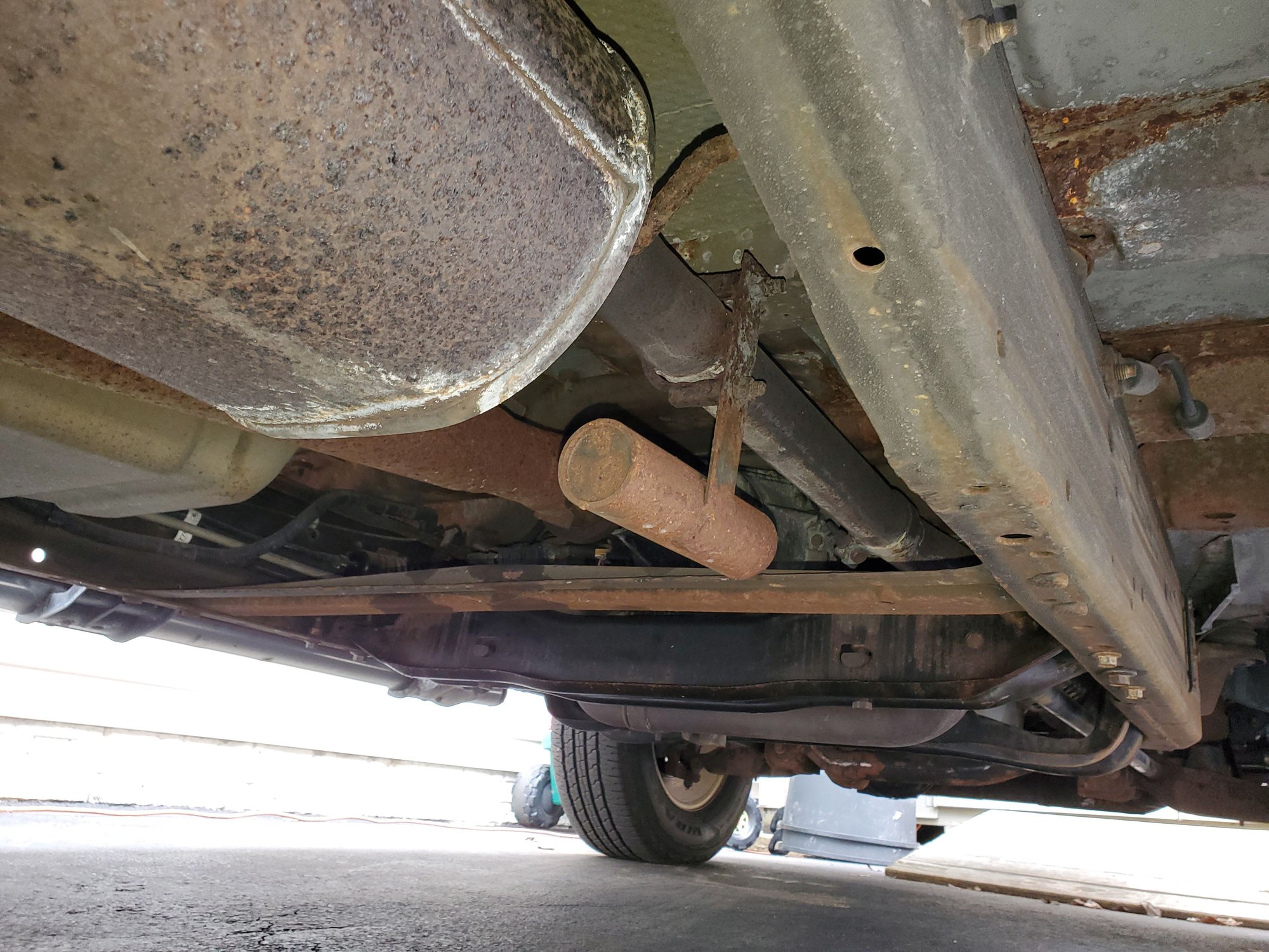 What is this piece hanging from the exhaust in front of the muffler