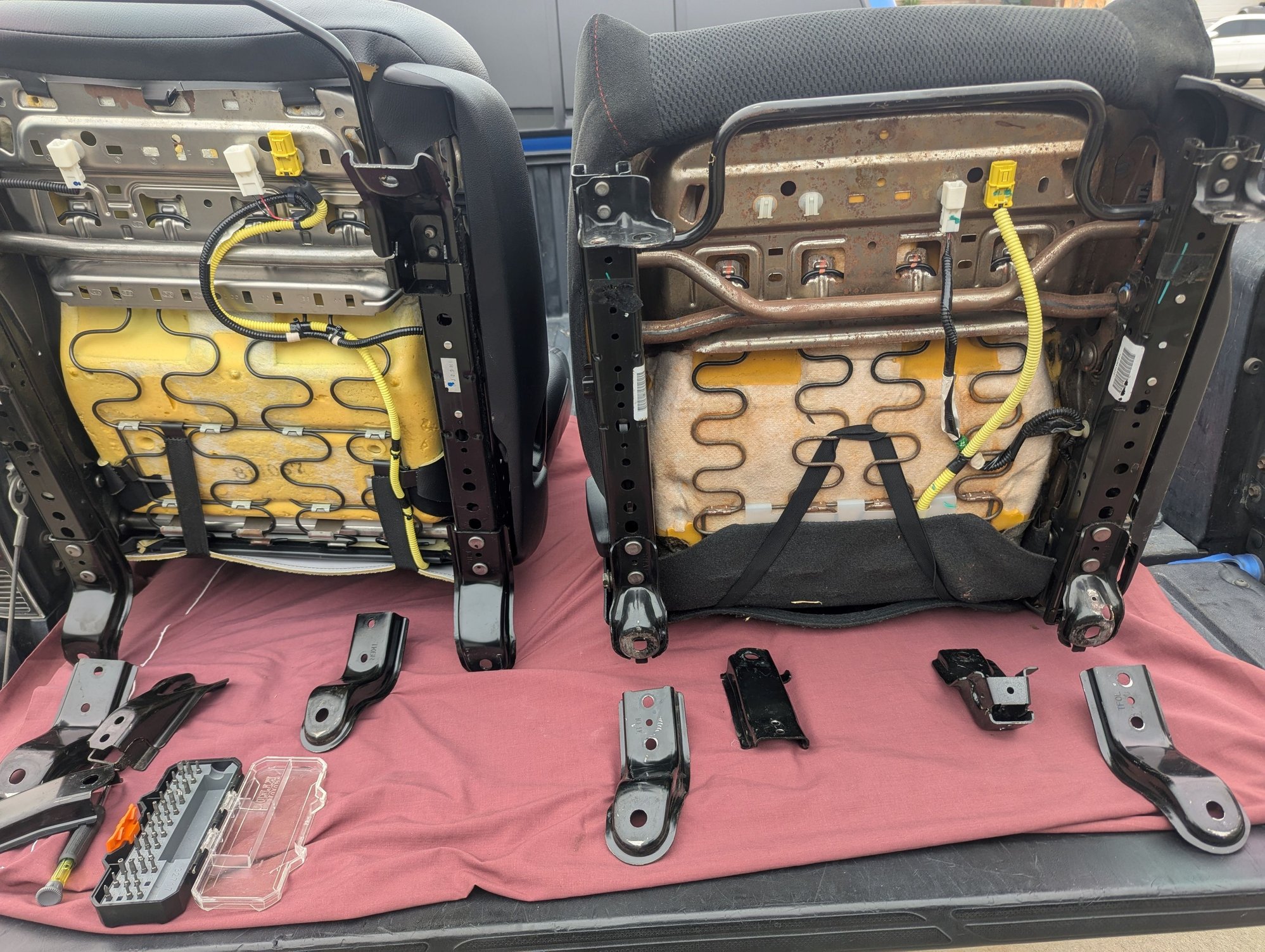Bottom side of both seats before any changes. Notice the SI seat at the right does not have the harness for the seat belt.