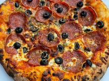 Green chile, pepperoni, black olives, and feta cheese on my side. Launched at 850 F and baked about 2 minutes. 