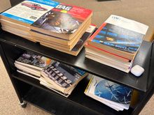 OAGs from July between 1990 and 2023. 2023’s is on the bottom of the second shelf at the right, and is actually an April edition. 