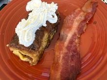 Eggnog French toast casserole w/ maple syrup and whipped cream (second slice). 