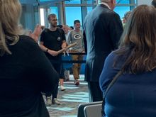 A crowd clapping as the surprised passengers deplane and were given a goodie bag upon arrival