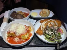 Flat iron steak, warm bread roll, chicken Milanese, and lasagna.  Welcome snack of the twisted breadstick was served with the beverage.  The tasty Calabrian chili oil was not available on our flight.

