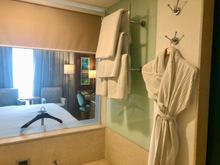 bathtub, window with blind and bathrobe