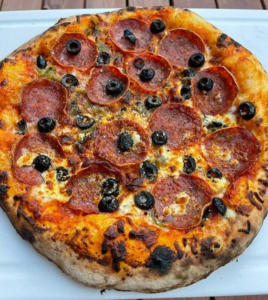 Green chile, pepperoni, black olives, and feta cheese on my side. Launched at 850 F and baked about 2 minutes. 