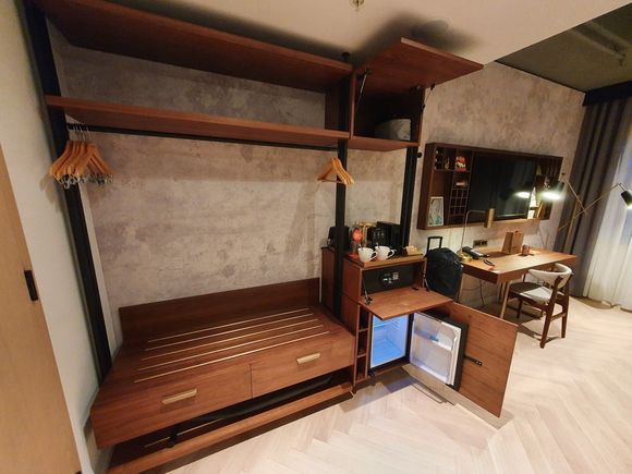 The open wardrobe (with cupboards open to show the safe, iron, fridge etc.