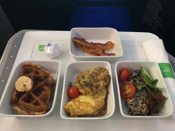 Clockwise from top: maple glazed bacon, smoked salmon salad, smoked Gouda & caramelized onion omelette, fried chicken & waffles