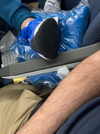 Leg and shoe position of neighboring seat mate after I had nudged it towards him. On two occasions, it stretched out fully with the leg perpendicular to the armrest, the heel of the shoe resting on the armrest with the toe pointing straight upwards 