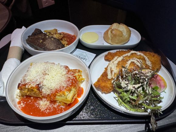 Flat iron steak, warm bread roll, chicken Milanese, and lasagna.  Welcome snack of the twisted breadstick was served with the beverage.  The tasty Calabrian chili oil was not available on our flight.

