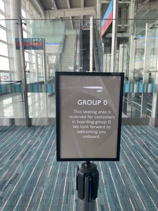 Group 0 sign and tense-barriered pen at DXB. Most contravening passengers were removed by regular patrols! 