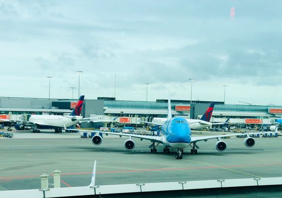 KLM 747 framed by Delta tails at Schiphol