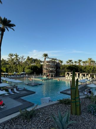 Pool area, water slide in distance, sandy area to the left of the slide.