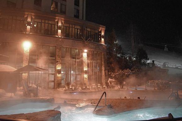 Hotel pools at night beside the ski-out