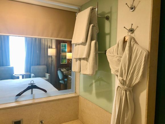 bathtub, window with blind and bathrobe