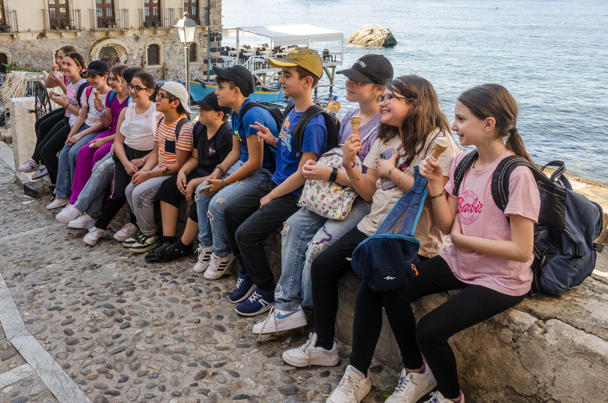 A school excursion visiting Chianalea. The Palazzo Scategna hotel where Stanley Tucci ate at the Il Principe restaurant during his CNN show is seen behind. The boy in the middle with the dark cap and I had a nice chat while gingerly trying each others mother tongues. Eventually, we gave him one of our Canadian flag pins. He later tracked us down in an alley to proudly show us that pin attached to his cap. Everyone smiles in the same language.